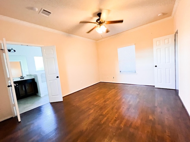 spare room featuring a textured ceiling, dark wood-type flooring, ceiling fan, and crown molding