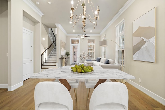 dining room with crown molding, light hardwood / wood-style flooring, and ceiling fan with notable chandelier