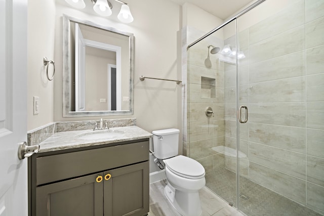 bathroom featuring vanity, toilet, and a shower with door