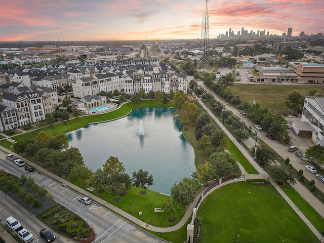 aerial view at dusk featuring a water view