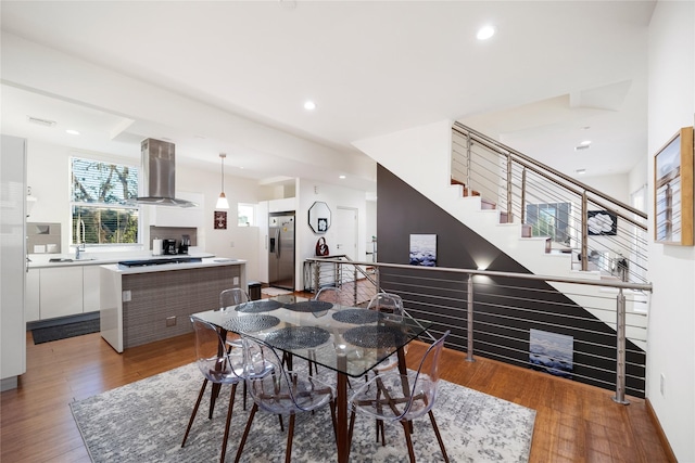 dining room featuring hardwood / wood-style flooring, a fireplace, and sink