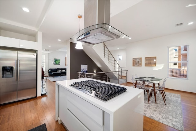 kitchen with a center island, stainless steel appliances, light hardwood / wood-style floors, island range hood, and white cabinets