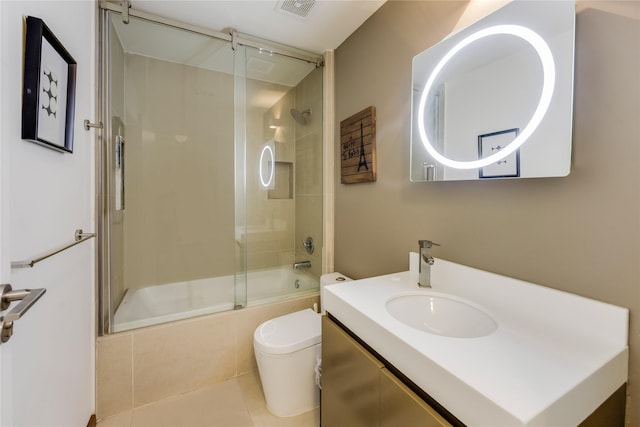 full bathroom with combined bath / shower with glass door, tile patterned floors, vanity, and toilet