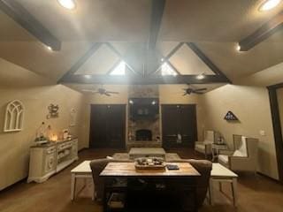 interior space featuring vaulted ceiling with beams, ceiling fan, and a fireplace