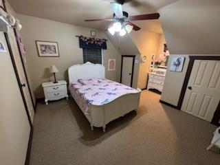 carpeted bedroom with ceiling fan and vaulted ceiling