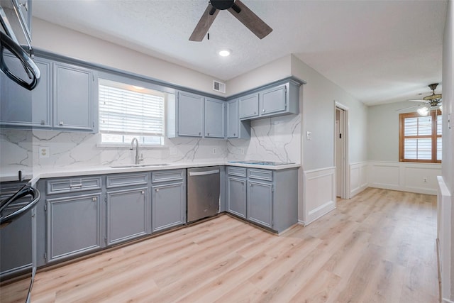 kitchen featuring dishwasher, light wood-type flooring, a wealth of natural light, and sink