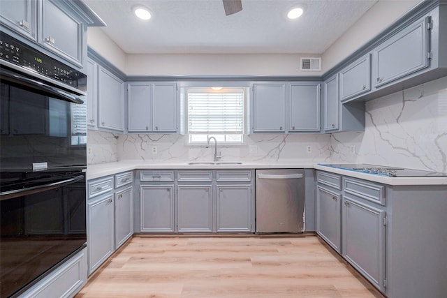 kitchen featuring sink, gray cabinets, light hardwood / wood-style flooring, and black appliances