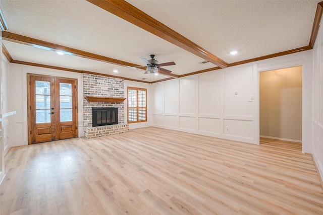 unfurnished living room with french doors, a textured ceiling, ceiling fan, light hardwood / wood-style flooring, and a fireplace