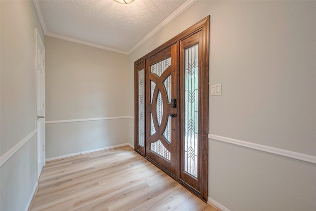 foyer with crown molding, light hardwood / wood-style floors, and a textured ceiling