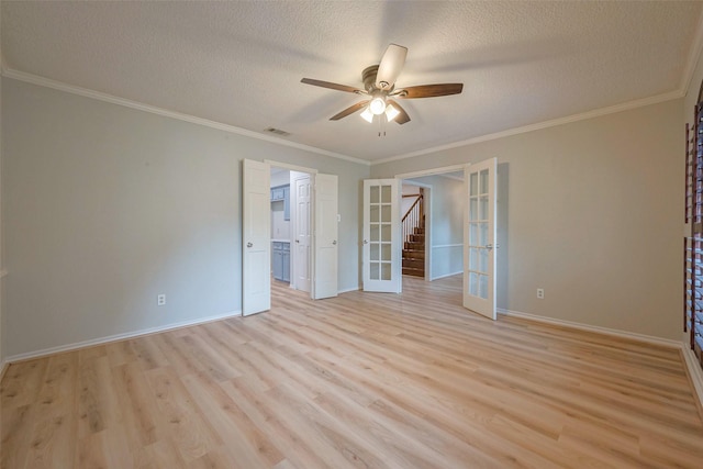 unfurnished room with ceiling fan, french doors, crown molding, a textured ceiling, and light wood-type flooring