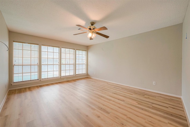 empty room featuring a textured ceiling, light hardwood / wood-style flooring, and ceiling fan