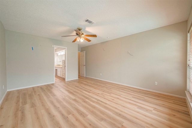 spare room with a textured ceiling, light wood-type flooring, and ceiling fan