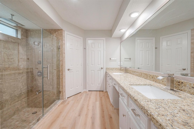 bathroom featuring hardwood / wood-style floors, vanity, and an enclosed shower