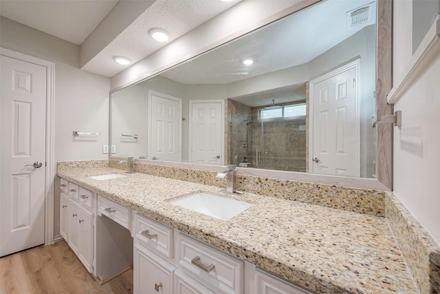 bathroom featuring hardwood / wood-style floors, vanity, and walk in shower