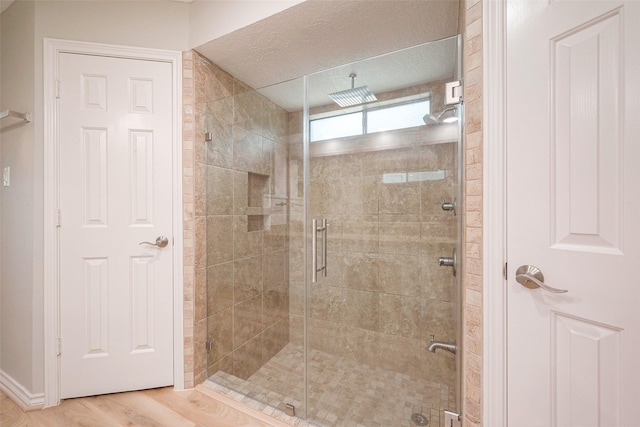 bathroom featuring hardwood / wood-style flooring and a shower with door