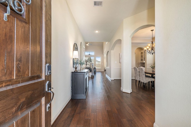 entrance foyer featuring an inviting chandelier and dark wood-type flooring