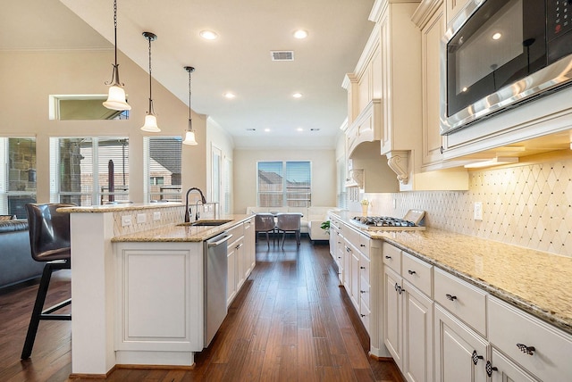 kitchen featuring a kitchen bar, dark hardwood / wood-style flooring, backsplash, stainless steel appliances, and sink