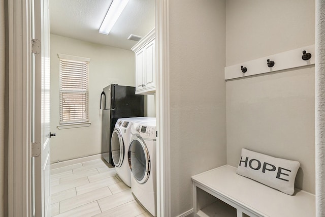 washroom featuring cabinets and washing machine and dryer