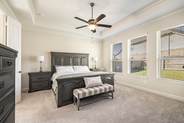 carpeted bedroom with a tray ceiling, ceiling fan, and crown molding