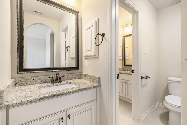 bathroom featuring tile patterned floors, vanity, and toilet