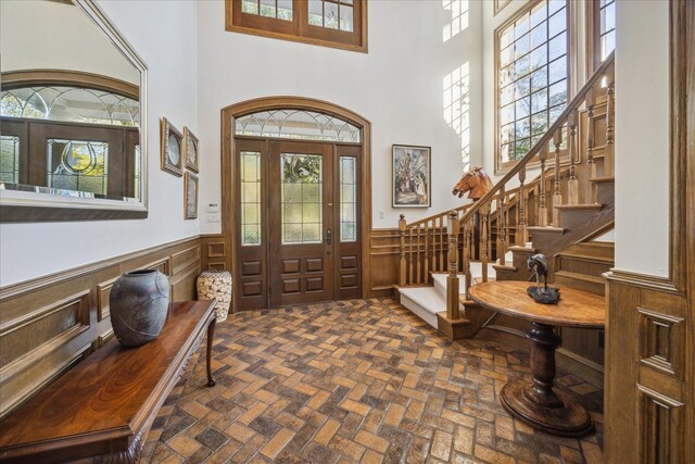 foyer entrance featuring a towering ceiling and plenty of natural light