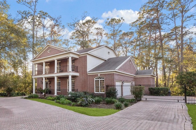 greek revival inspired property featuring a garage and a balcony