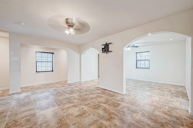 spare room with ceiling fan and a textured ceiling