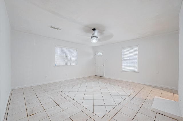 spare room with ceiling fan and light tile patterned floors