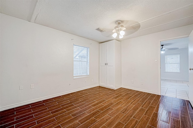 empty room featuring a textured ceiling and ceiling fan