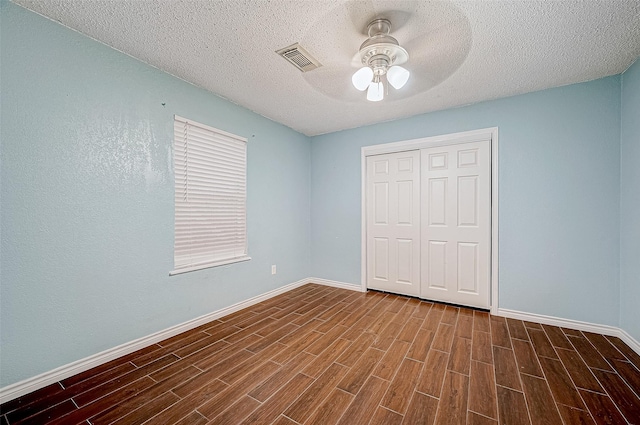 unfurnished bedroom with ceiling fan, a textured ceiling, and a closet