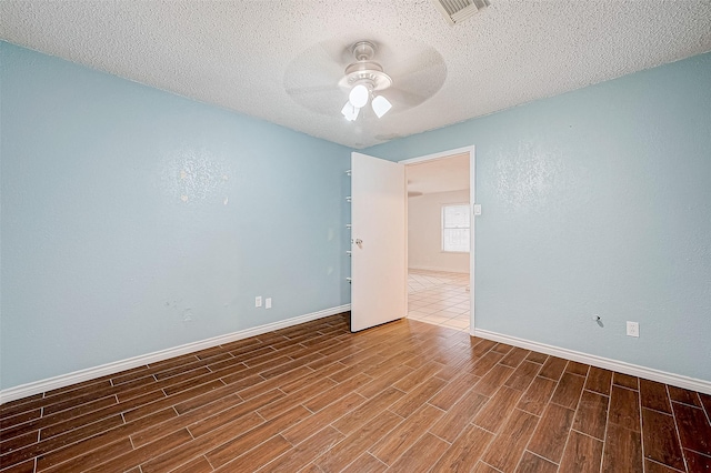 spare room with a textured ceiling and ceiling fan