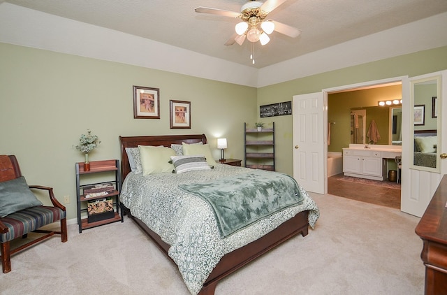 bedroom featuring ceiling fan, light carpet, connected bathroom, and vaulted ceiling