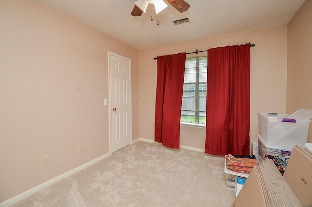 interior space with ceiling fan and light carpet