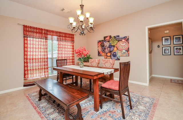 tiled dining room with an inviting chandelier