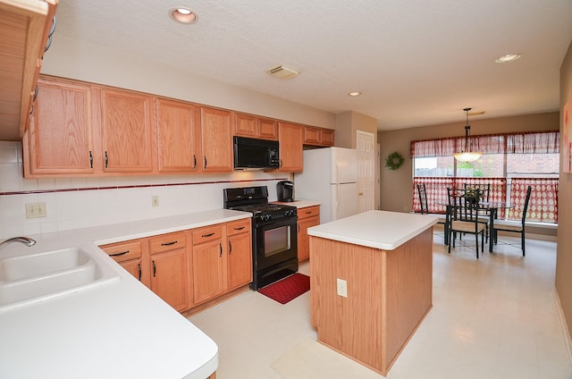 kitchen featuring black appliances, a kitchen island, sink, and hanging light fixtures