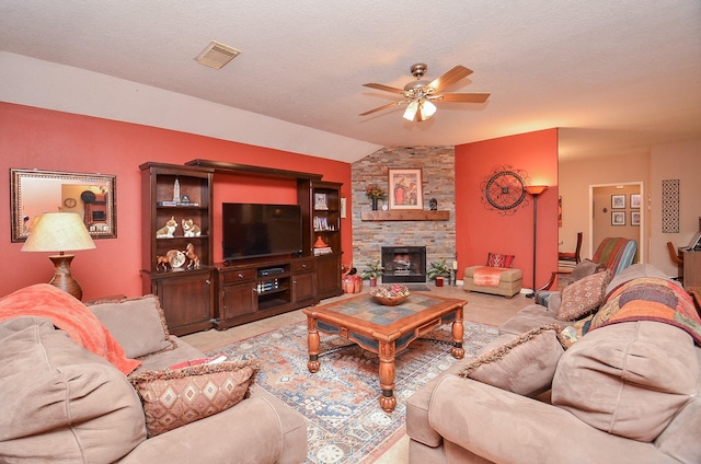 living room with a stone fireplace, ceiling fan, light carpet, and vaulted ceiling