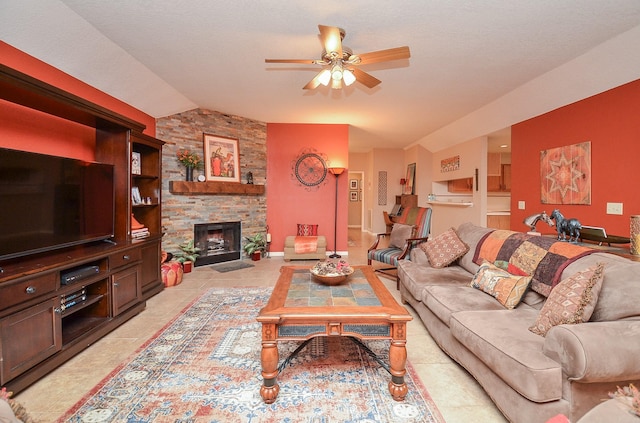 tiled living room with a fireplace, vaulted ceiling, and ceiling fan