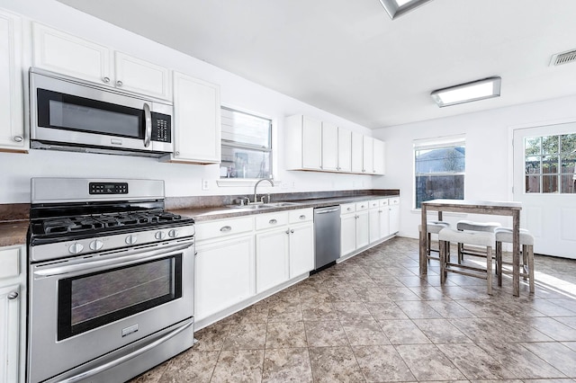 kitchen with sink, white cabinets, and stainless steel appliances