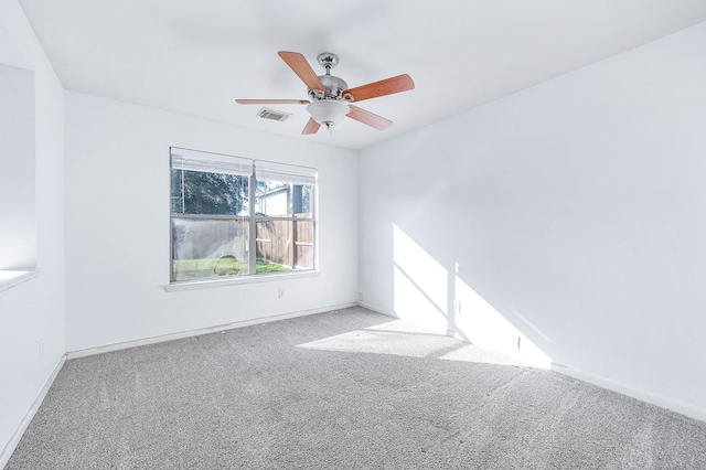 carpeted spare room featuring ceiling fan