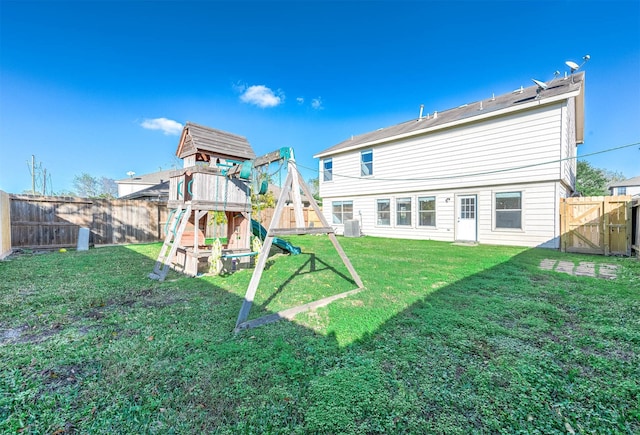 rear view of property featuring a yard and a playground