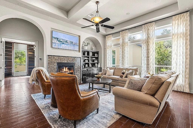 living room with ceiling fan, dark hardwood / wood-style floors, and a fireplace