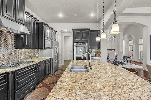 kitchen featuring tasteful backsplash, light stone countertops, sink, and stainless steel appliances