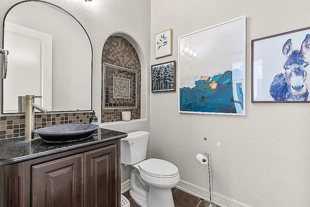 bathroom with tile patterned floors, decorative backsplash, vanity, and toilet