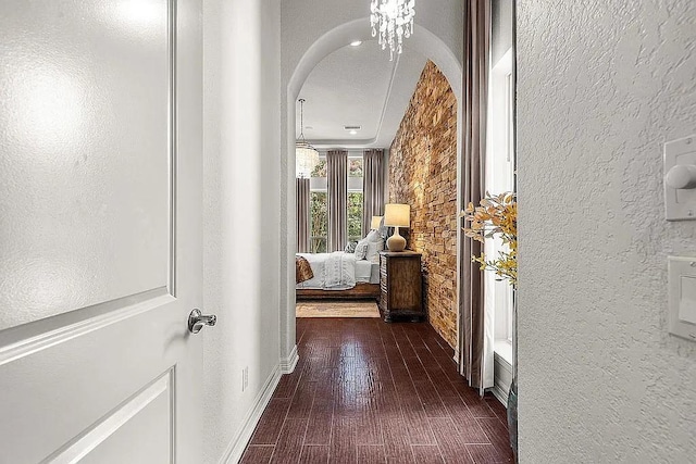 hall with a chandelier and dark hardwood / wood-style floors