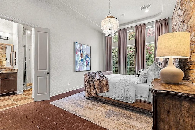 bedroom featuring a textured ceiling, a notable chandelier, and ensuite bathroom