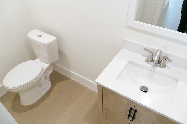 bathroom with hardwood / wood-style flooring, vanity, and toilet