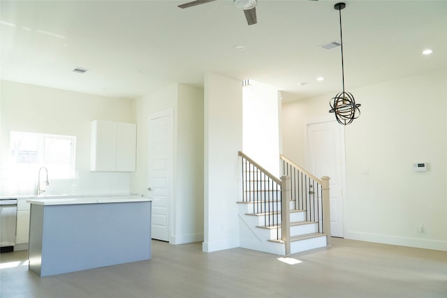 kitchen with a kitchen island, white cabinets, ceiling fan, and decorative light fixtures