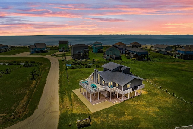 aerial view at dusk featuring a water view