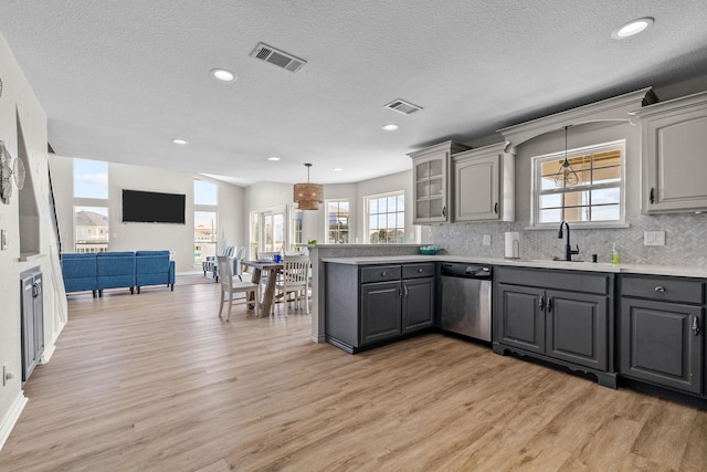 kitchen featuring dishwasher, sink, light hardwood / wood-style floors, a textured ceiling, and gray cabinets