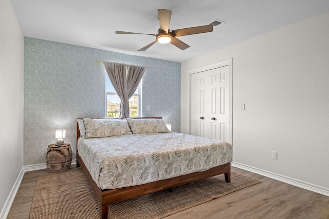 bedroom with ceiling fan, a closet, and hardwood / wood-style floors